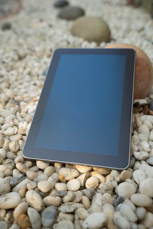 digital tablet device on stone in garden