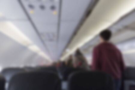 passenger walking in aisle in airplane cabin, blur backgroundの写真素材