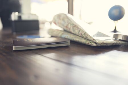 passport, compass, credit card,  camera, map on wooden table for use as traveling concept (vintage tone and selected focus)の写真素材