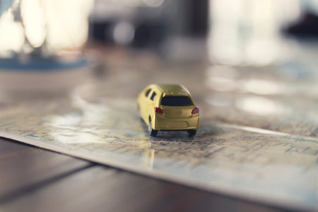 yellow car figurine on map for trip vacation traveling concept, selected focus and vintage tone