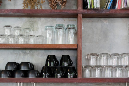 cup and glass on wooden shelf for use as kitchen background