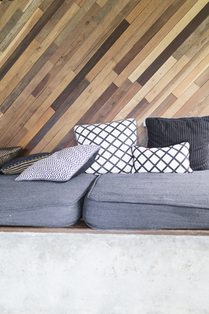 gray cushion and pillow with skew wooden wallの写真素材