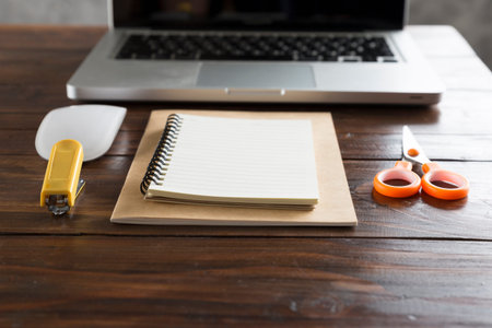 laptop computer and notebook on wooden office deskの写真素材