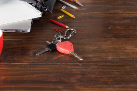 car key, laptop computer and notebook on wooden office deskの写真素材