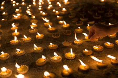 People light candle to pay respect to buddha relic at buddhist templeの写真素材