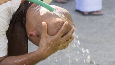 Lampang, Thailand - July 18, 2016: man who will become buddhism monk washing his head after shaving in ordination ceremony at Bunyanupab temple in Lampang, Thailand on July 18, 2016.のeditorial素材