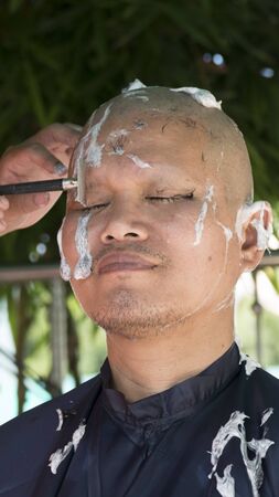 Lampang, Thailand - July 18, 2016: monk shave hair of man who will become buddhism monk in ordination ceremony at Bunyanupab temple in Lampang, Thailand on July 18, 2016.のeditorial素材