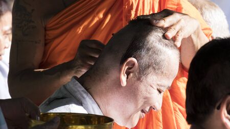 Lampang, Thailand - July 18, 2016: monk shave hair of man who will become buddhism monk in ordination ceremony at Bunyanupab temple in Lampang, Thailand on July 18, 2016.のeditorial素材