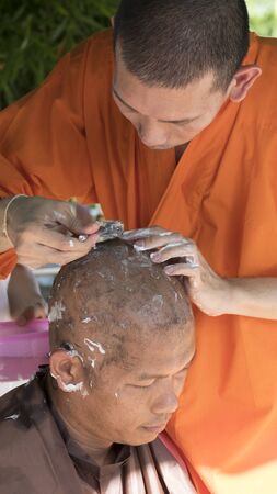 Lampang, Thailand - July 18, 2016: monk shave hair of man who will become buddhism monk in ordination ceremony at Bunyanupab temple in Lampang, Thailand on July 18, 2016.のeditorial素材