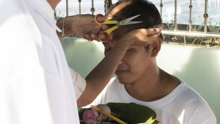 Lampang, Thailand - July 18, 2016: people cut hair of man who will become buddhism monk in ordination ceremony at Bunyanupab temple in Lampang, Thailand on July 18, 2016.のeditorial素材