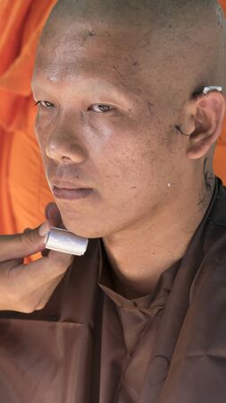 Lampang, Thailand - July 18, 2016: monk shave hair of man who will become buddhism monk in ordination ceremony at Bunyanupab temple in Lampang, Thailand on July 18, 2016.のeditorial素材