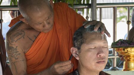 Lampang, Thailand - July 18, 2016: monk shave hair of man who will become buddhism monk in ordination ceremony at Bunyanupab temple in Lampang, Thailand on July 18, 2016.のeditorial素材