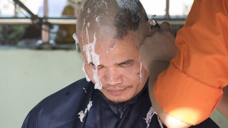 Lampang, Thailand - July 18, 2016: monk shave hair of man who will become buddhism monk in ordination ceremony at Bunyanupab temple in Lampang, Thailand on July 18, 2016.のeditorial素材