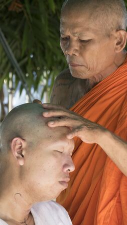 Lampang, Thailand - July 18, 2016: monk shave hair of man who will become buddhism monk in ordination ceremony at Bunyanupab temple in Lampang, Thailand on July 18, 2016.のeditorial素材