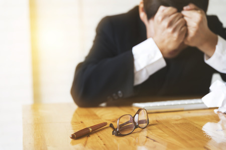 businessman with hand on head in office - upset, frustrate, stress concep t- blur for use as backgroundの写真素材