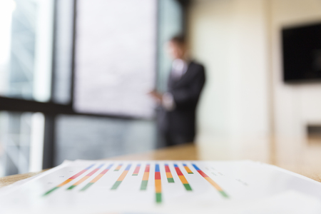 business analysis chart report with background of businessman in suit standing beside office windowの写真素材