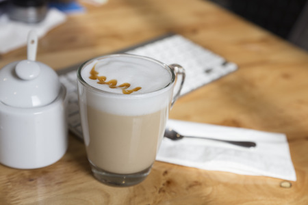 hot cappuccino coffee drink cup with sugar mug on wooden deskの写真素材