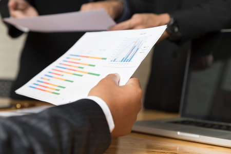 businessman meeting, analyzing and discussing with laptop computer and paperwork documentの写真素材