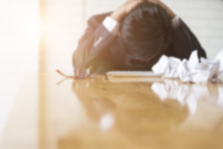 businessman with hand on head in office - upset, frustrate, stress concept - blur for use as backgroundの写真素材