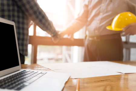 architect engineer shaking hands beside window - business teamwork, cooperation, success...