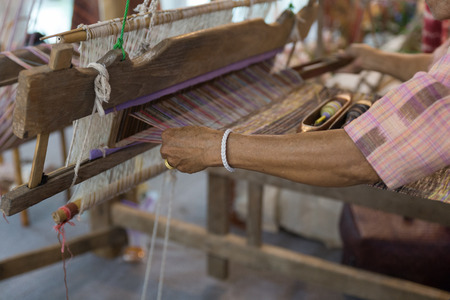 traditional hand-weaving loom being used to make clothの写真素材