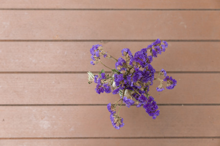 purple flower bunch in glass vase on wood floor at patio - top viewの写真素材