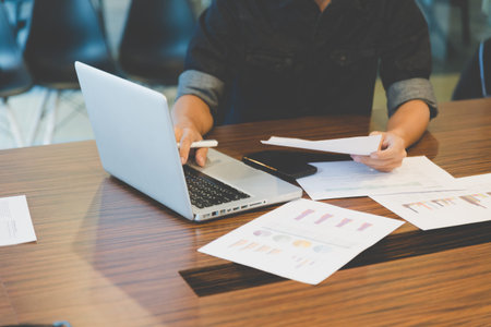 people working with document and laptop computer in office workplace - blur for background