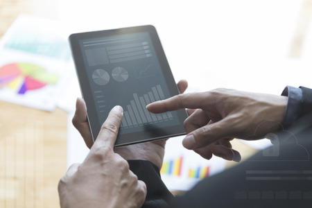 businessman meeting, analyzing and discussing with tablet and paperwork documentの写真素材