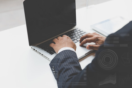 businessman typing on laptop computer in office workplaceの写真素材