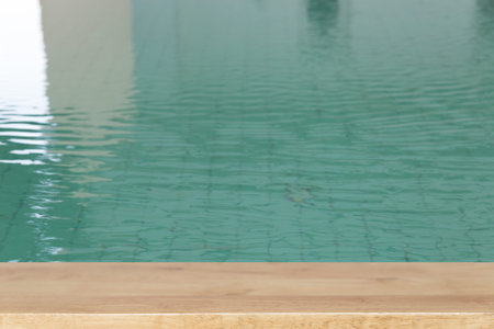 wood table for montage or display your product with swimming pool background