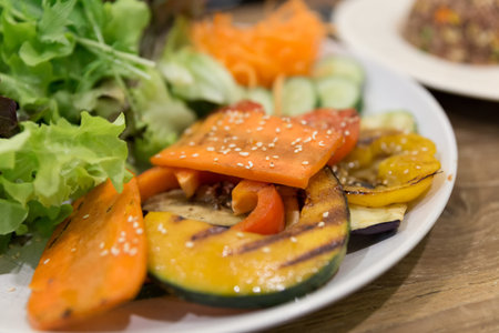 grilled carrot, sweet pepper and pumpkin with mixed vegetable salad on white plate