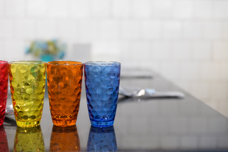 colorful glass, spoon, fork, tableware on table in restaurantの写真素材