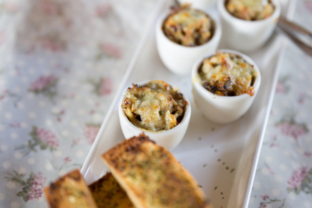 grilled clams in small cup and garlic bread on plateの写真素材