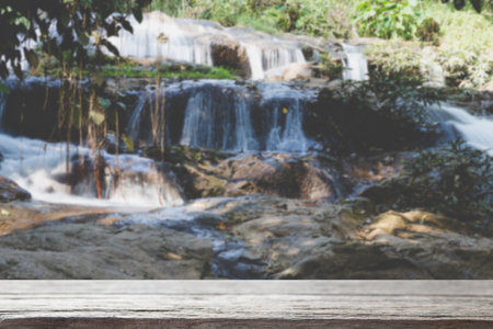 wood table for montage or display your product with blur background of waterfall cascade and creek stream in forestの写真素材