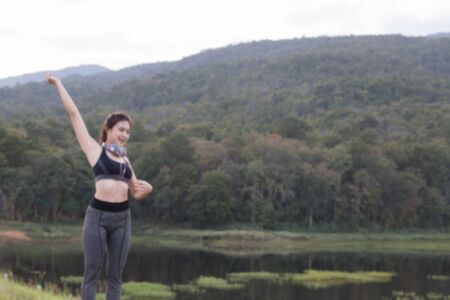 fitness, sport and healthy lifestyle concept - happy teenage woman or sportswoman outdoors in park (blur image)の写真素材