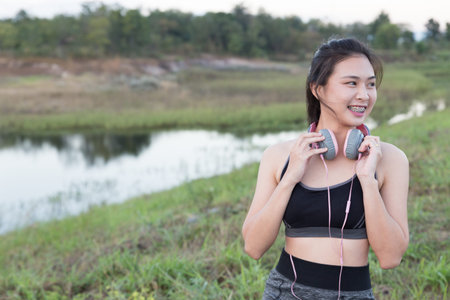 fitness, sport and healthy lifestyle concept - happy teenage woman or sportswoman with earphones...