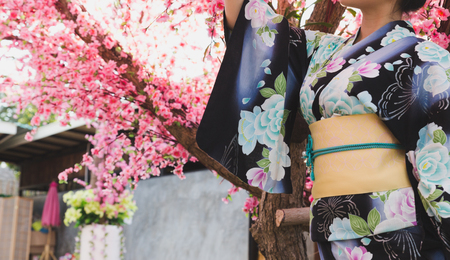 beautiful asian woman wearing traditional japanese kimono and pink cherry blossom flowerの写真素材