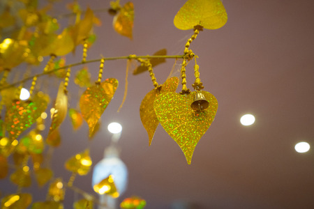 Gold leaves hanging on golden tree, decorating yellow pho leaf, symbol of buddhism religionの写真素材