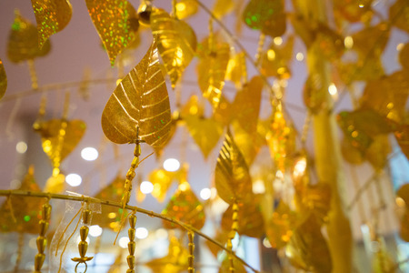 Gold leaves hanging on golden tree, decorating yellow pho leaf, symbol of buddhism religionの写真素材