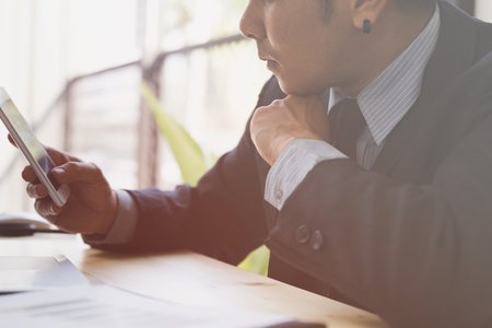 Businessman analyzing charts and graphs with smartphone and computer in office. business analysis and strategy concept.の写真素材