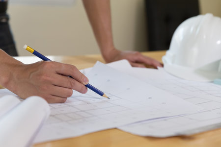 Architect or engineer working on blueprint at workplace - architectural project, Construction...