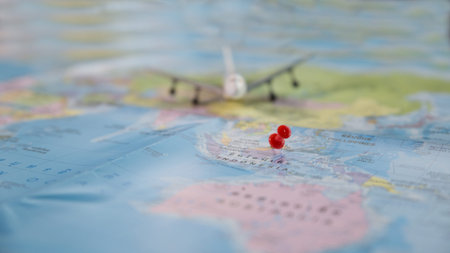 selective focus of swamp red pin with miniature airplane on map, abstract background for travel...