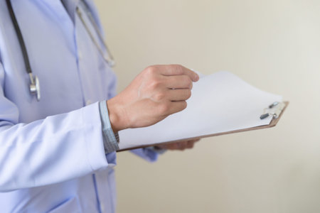 doctor hand holding clipboard. Medical care, insurance, prescription, paper work or career concept. Physician ready to examine patient and helpの写真素材