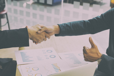 two businessman handshaking and show a thumb up for successful deal after negotiation in meeting. business partnership corporate concept.の写真素材