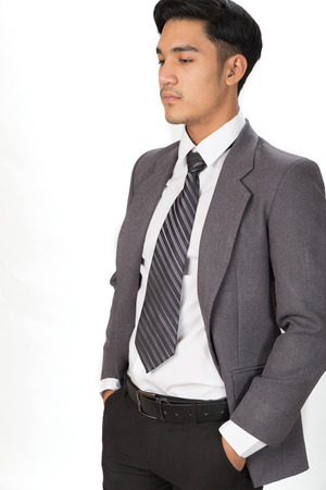 A young handsome male startup entrepreneur Businessman wearing gray suit standing and posing over white backgroundの写真素材