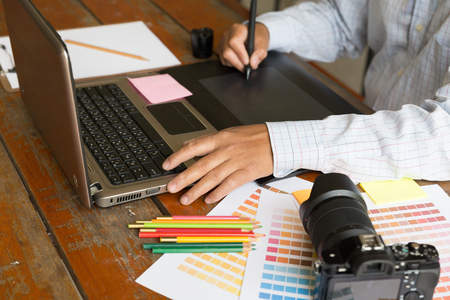 freelance artist graphic designer using digital tablet, computer, creative man working with color swatch palette catalog samples for selection - Creativity Editor Ideas Designer Conceptの写真素材