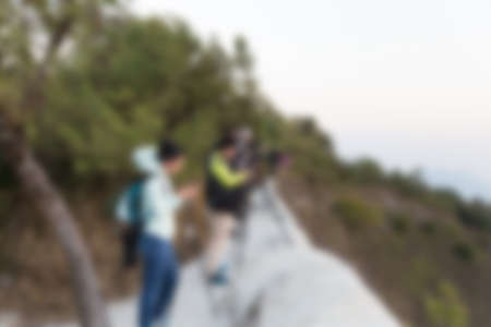 many photographers with tripod take photo on hill at sunset, blur image for backgroundの写真素材