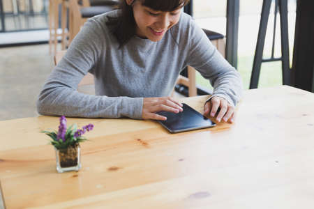 asian girl female teenager studying at school. Student reading something on digital tablet in cafe  - education, lifestyle and learning conceptの写真素材