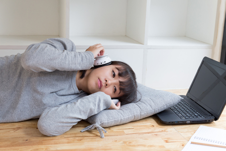 asian girl female teenager student lying and listening to music from headphone - lifestyle and education conceptの写真素材