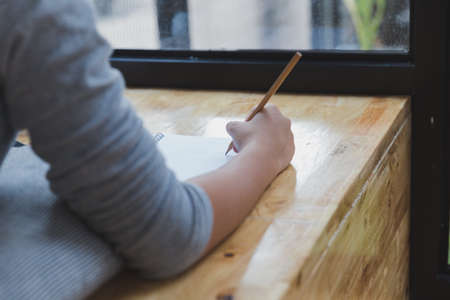 asian girl female teenager lying on wood floor and writing word " I love you"  on notepadの写真素材